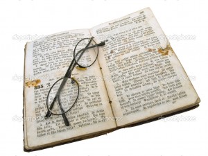 Isolated old open book with glasses against the white background